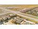 An aerial view showcases the neighborhood homes, the surrounding desert, and the roadway at 10906 Mila Landing Ave, Las Vegas, NV 89166