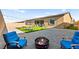 Inviting backyard with gravel, a green lawn, fire pit, and comfortable seating, perfect for outdoor relaxation at 10906 Mila Landing Ave, Las Vegas, NV 89166
