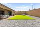 Large backyard with a lush lawn, gravel landscaping, and outdoor seating, ideal for entertaining at 10906 Mila Landing Ave, Las Vegas, NV 89166