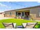 Cozy backyard with patio furniture and lush green lawn, perfect for entertaining guests at 10906 Mila Landing Ave, Las Vegas, NV 89166