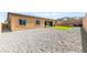 Expansive backyard showcasing gravel landscaping, a patch of green grass, and home exterior at 10906 Mila Landing Ave, Las Vegas, NV 89166