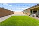 Spacious backyard showcasing a well-manicured lawn, gravel landscaping, and tasteful outdoor decor at 10906 Mila Landing Ave, Las Vegas, NV 89166