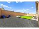 Wide view of the backyard featuring gravel landscaping, a small lawn, and comfortable seating area for relaxation at 10906 Mila Landing Ave, Las Vegas, NV 89166