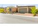 Beautiful single-story home featuring a three-car garage, stone accents, and a well-manicured front yard at 10906 Mila Landing Ave, Las Vegas, NV 89166