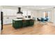 Modern kitchen featuring white cabinets, a green island with seating, and stainless steel appliances at 10906 Mila Landing Ave, Las Vegas, NV 89166