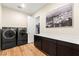 Modern laundry room with a pair of washer and dryer, storage, and countertop space at 10906 Mila Landing Ave, Las Vegas, NV 89166