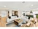 Spacious living room showcasing hardwood floors, a modern sofa, and access to the adjacent dining and kitchen area at 10906 Mila Landing Ave, Las Vegas, NV 89166