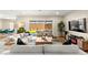 Comfortable living room features an expansive sectional sofa, a modern entertainment center, and abundant natural light at 10906 Mila Landing Ave, Las Vegas, NV 89166