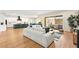Stylish living room with hardwood floors, a large sectional sofa, and seamless flow to the kitchen and patio at 10906 Mila Landing Ave, Las Vegas, NV 89166