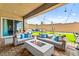 Comfortable patio with modern furniture, a fire pit, and a spacious lawn for outdoor enjoyment at 10906 Mila Landing Ave, Las Vegas, NV 89166