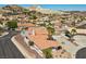 Expansive home with an orange tile roof, desert landscaping, and a private pool nestled within a hillside community at 1105 Malachite Ct, Henderson, NV 89011