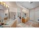 Bright bathroom featuring dual sinks, neutral tile flooring, and a view to the bedroom at 1105 Malachite Ct, Henderson, NV 89011