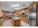 Lovely open kitchen boasting stone countertops, center island with a sink, and stainless steel refrigerator at 1105 Malachite Ct, Henderson, NV 89011