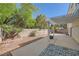 Inviting backyard featuring a spacious patio, well-manicured trees, and privacy wall at 1116 Avellino Ln, Las Vegas, NV 89144