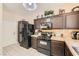 Well-equipped kitchen featuring dark cabinetry, stone countertops, and modern appliances at 1116 Avellino Ln, Las Vegas, NV 89144