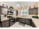 Kitchen with dark cabinets, tiled backsplash, and modern appliances, perfect for cooking and entertaining at 1116 Avellino Ln, Las Vegas, NV 89144