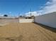 An empty backyard with full gravel coverage has a tall white perimeter wall at 129 Maple St, Henderson, NV 89015