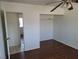 A well-lit bedroom features wood floors, ceiling fan, and a closet for ample storage at 129 Maple St, Henderson, NV 89015