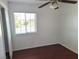 A well-lit bedroom features wood floors, ceiling fan, and a window for natural light at 129 Maple St, Henderson, NV 89015