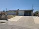 Exterior shot of a single-story house with a large driveway and carport at 129 Maple St, Henderson, NV 89015