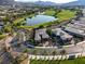 Beautiful aerial view of a home in a golf course community, showcasing lush greenery, a serene lake, and mountain views at 15 Reflection Bay Dr, Henderson, NV 89011