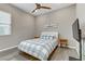 Cozy bedroom with gray wood flooring, ceiling fan, large window, and flat screen TV at 15 Reflection Bay Dr, Henderson, NV 89011