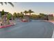 Paved community entrance with lush landscaping, stone pillars, mature palm trees, and gated entry at 15 Reflection Bay Dr, Henderson, NV 89011