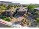Exterior of home with stone facade, desert landscaping, and brick paver driveway at 15 Reflection Bay Dr, Henderson, NV 89011