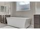 This luxurious bathroom boasts a modern soaking tub, framed mirrors, and stone countertops at 15 Reflection Bay Dr, Henderson, NV 89011