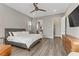 This main bedroom features a sleek gray platform bed frame, gray wood floors, and ensuite bathroom access at 15 Reflection Bay Dr, Henderson, NV 89011