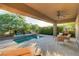 Covered patio with ceiling fan, comfortable seating, and splash pool with tiled water feature at 15 Reflection Bay Dr, Henderson, NV 89011