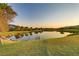 Picturesque view of pond and lush green golf course at sunset, showcasing a tranquil environment at 15 Reflection Bay Dr, Henderson, NV 89011