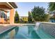 Beautiful splash pool features a waterfall feature and meticulously maintained landscaping in the backyard at 15 Reflection Bay Dr, Henderson, NV 89011