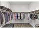 Spacious walk-in closet with built-in shelving, hanging racks, and gray wood flooring at 15 Reflection Bay Dr, Henderson, NV 89011