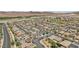 Expansive aerial view showcases a neighborhood with desert landscape and modern houses, some equipped with solar panels at 184 Bird Cove Ave, Henderson, NV 89011
