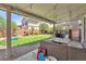 Inviting backyard with a covered patio, outdoor seating, and well-maintained artificial grass at 184 Bird Cove Ave, Henderson, NV 89011