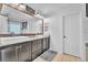 Bathroom featuring double sinks, granite countertops, modern fixtures, and shiplap accent wall at 184 Bird Cove Ave, Henderson, NV 89011