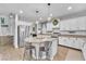 Well-lit kitchen featuring an island with seating, stainless appliances, and white cabinetry at 184 Bird Cove Ave, Henderson, NV 89011