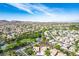 Panoramic aerial view of a lush community with mountain views, a golf course, and green spaces at 1978 Kachina Mountain Dr, Henderson, NV 89012