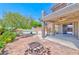 A spacious outdoor area featuring a fire pit, a covered patio, a spiral staircase, and lush vegetation at 201 Palmarosa St, Henderson, NV 89015