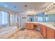 Bathroom with double sinks, a tub, a glass enclosed shower, and tile floors at 201 Palmarosa St, Henderson, NV 89015
