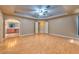 Bedroom featuring wood-look floors, tray ceiling, and an arched doorway to the bathroom at 201 Palmarosa St, Henderson, NV 89015