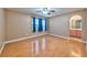 Bedroom featuring wood-look floors, ceiling fan, and an arched doorway to the bathroom at 201 Palmarosa St, Henderson, NV 89015