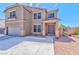 A charming two-story home with a desert landscape, a two-car garage, and a welcoming double-door entrance at 201 Palmarosa St, Henderson, NV 89015