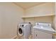 Laundry room featuring a washing machine, dryer, and a shelf for storage at 201 Palmarosa St, Henderson, NV 89015