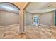 Open concept living room featuring tile floors, natural light, and arched doorways at 201 Palmarosa St, Henderson, NV 89015