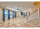 Bright living room with tile flooring, large windows, and a staircase leading to the upper level at 201 Palmarosa St, Henderson, NV 89015