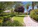 Backyard featuring a lush garden, brick path, and palm trees with shade at 2050 W Warm Springs Rd # 823, Henderson, NV 89014