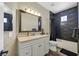 Stylish bathroom featuring a white vanity and a shower-tub combo with dark tile accents at 2050 W Warm Springs Rd # 823, Henderson, NV 89014