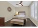 Bedroom with modern decor, dark wood floors, a bench, and bright, shuttered windows at 2050 W Warm Springs Rd # 823, Henderson, NV 89014